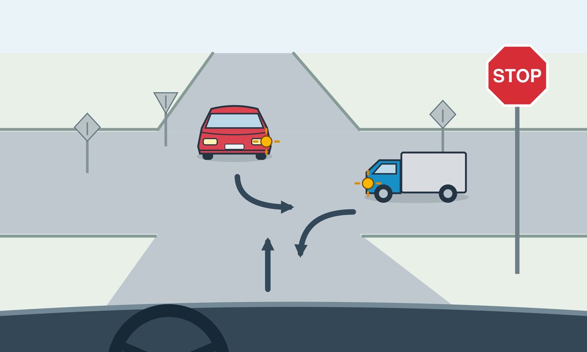 View from a car pointing straight ahead at a STOP sign. A red car opposite signals a left turn toward the image right. A blue lorry on the right signals a left turn toward the foreground.