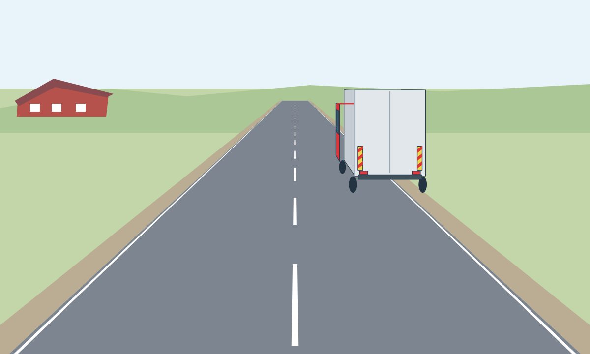 A lorry at the edge of a rural carriageway with a narrow shoulder.