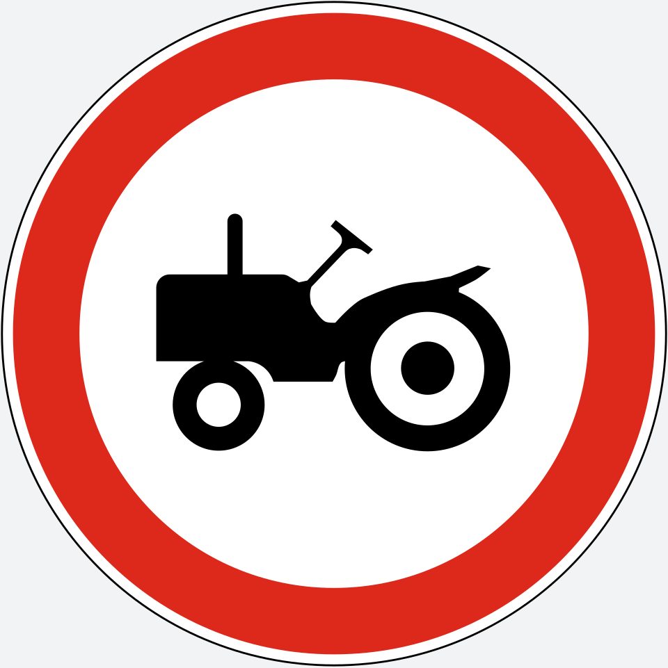 White circle with a red border; a black tractor facing left, with a small front wheel and a large rear wheel.