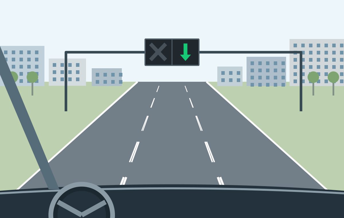 Driver view in a middle lane beneath a green downward arrow, with paired broken lane markings.