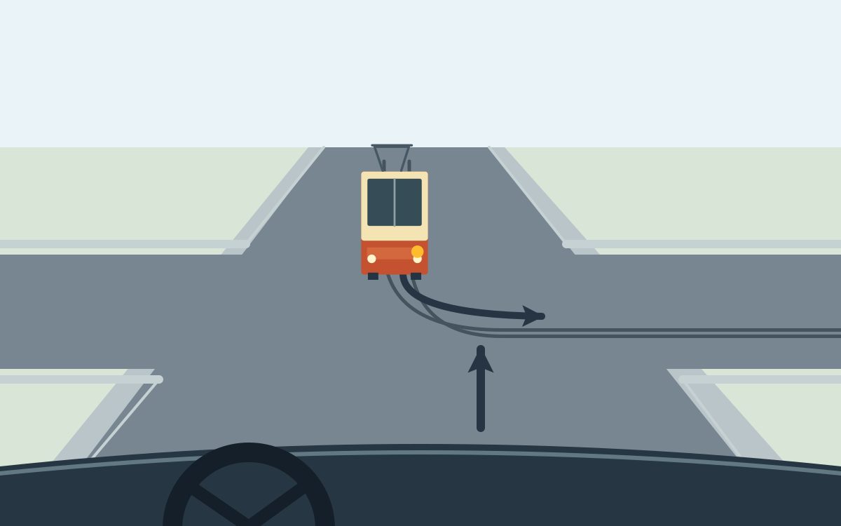 View from behind a steering wheel with a straight foreground arrow. An orange and cream tram opposite has an amber screen-right lamp. Two rails and the tram arrow curve right across the foreground path. No signs or traffic lights are shown.
