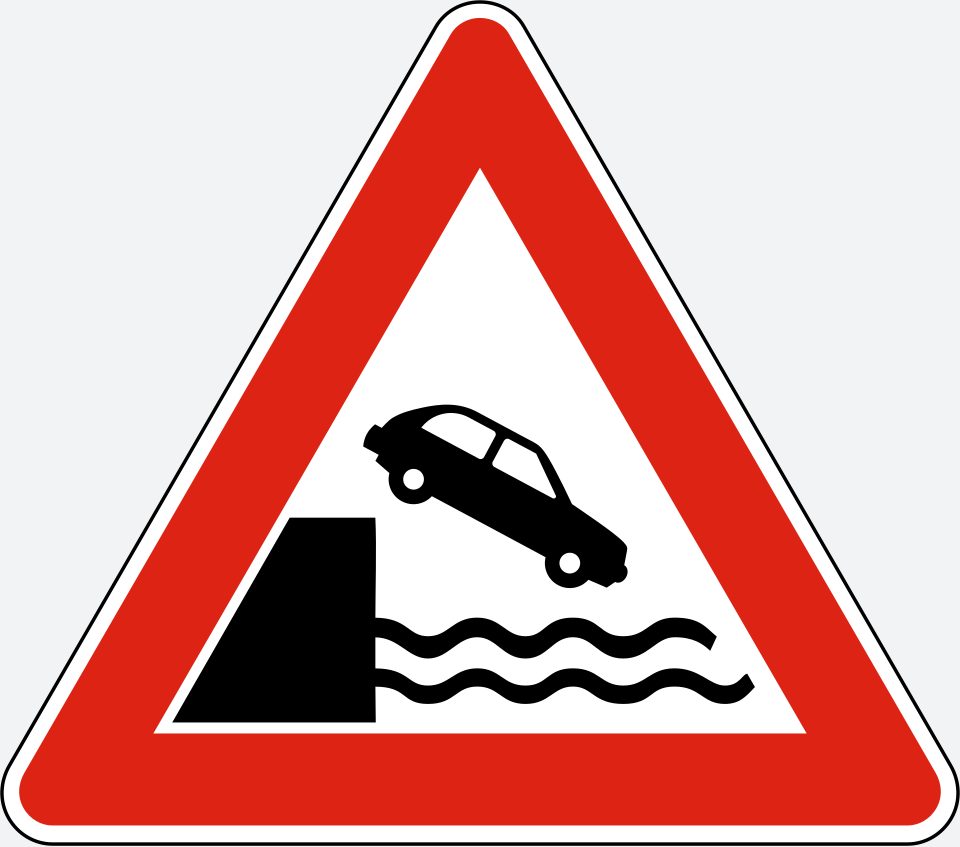 Upright white triangle with a red border; a black car slopes nose-down to the right from a vertical bank above wavy water lines.