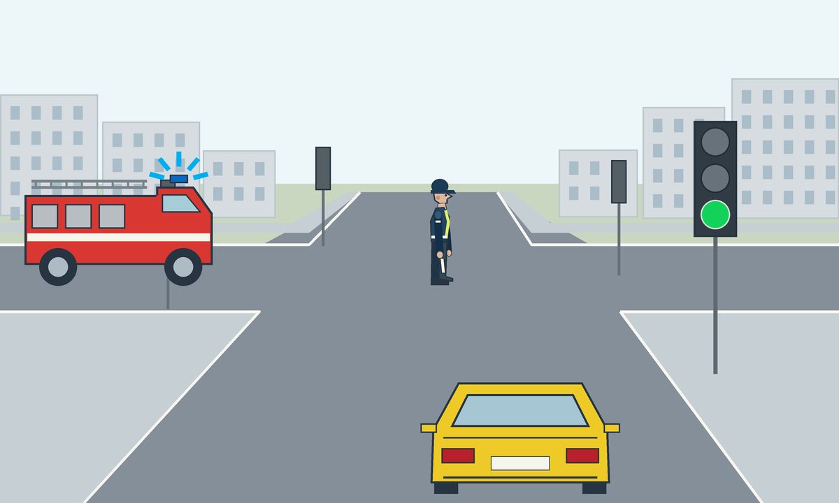 A yellow car, fire engine, traffic controller and green traffic light at a junction.