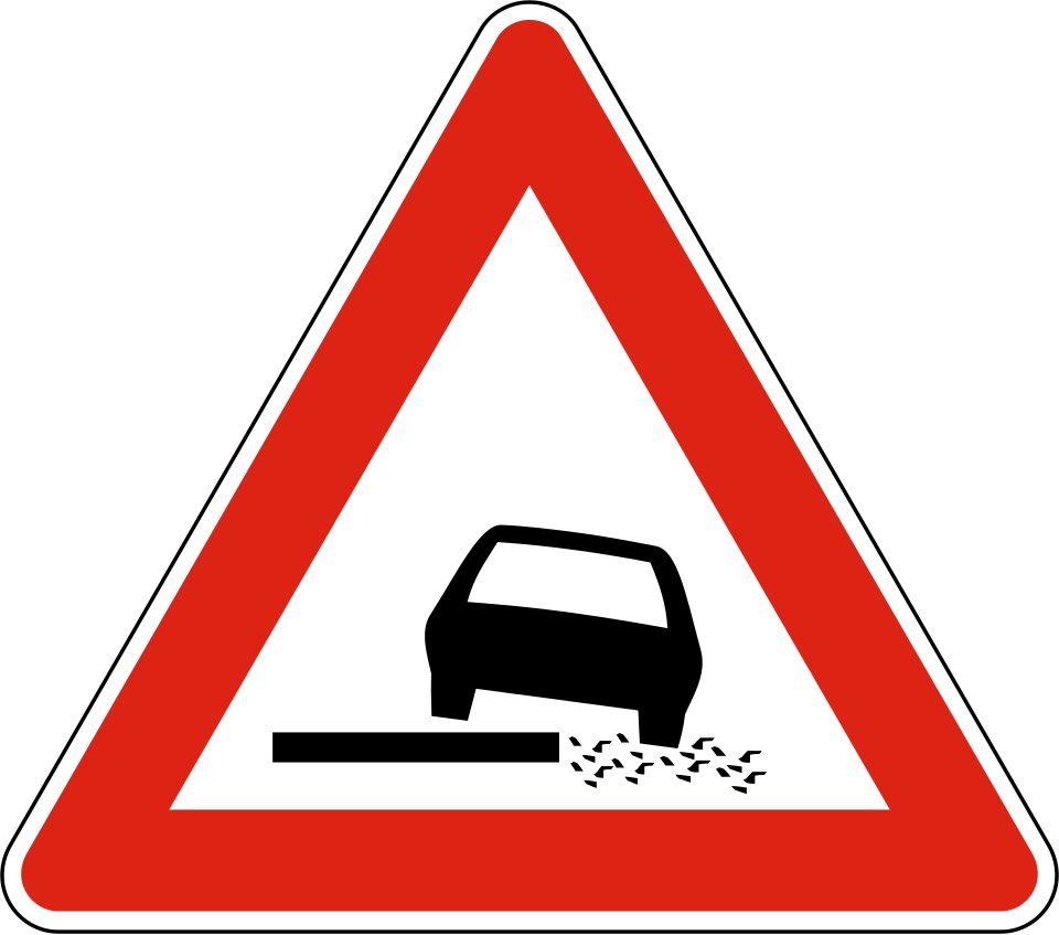 Red-bordered triangle showing a tilted car beside an uneven edge.