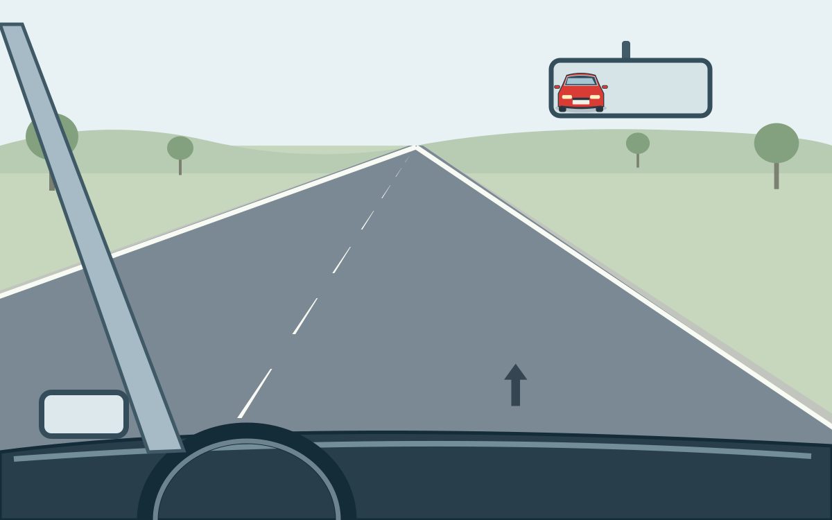 View from a car in the right lane of a rural road; a red car is visible in the interior mirror.