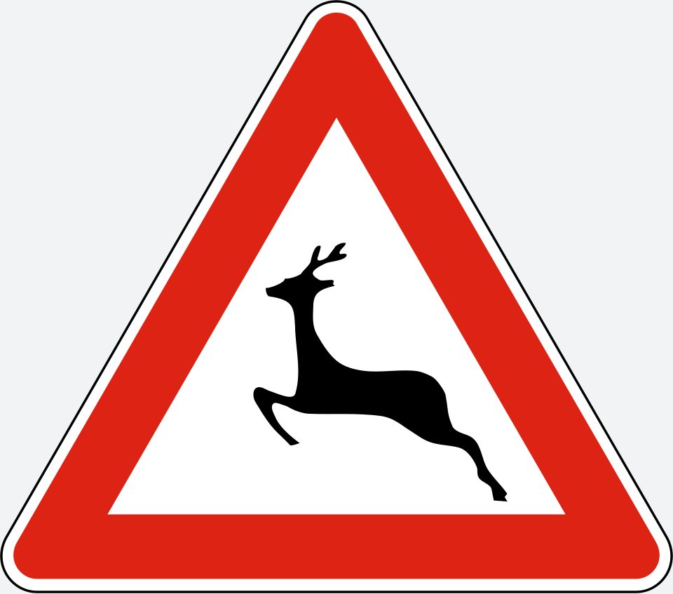 Upright white triangle with a red border; a black deer silhouette leaping left.