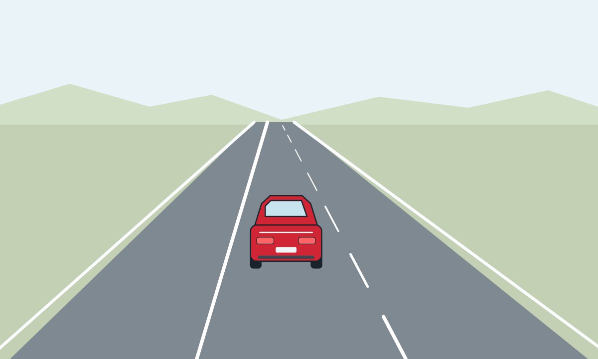 Rear view of a red car between a solid line on its left and a broken line on its right.