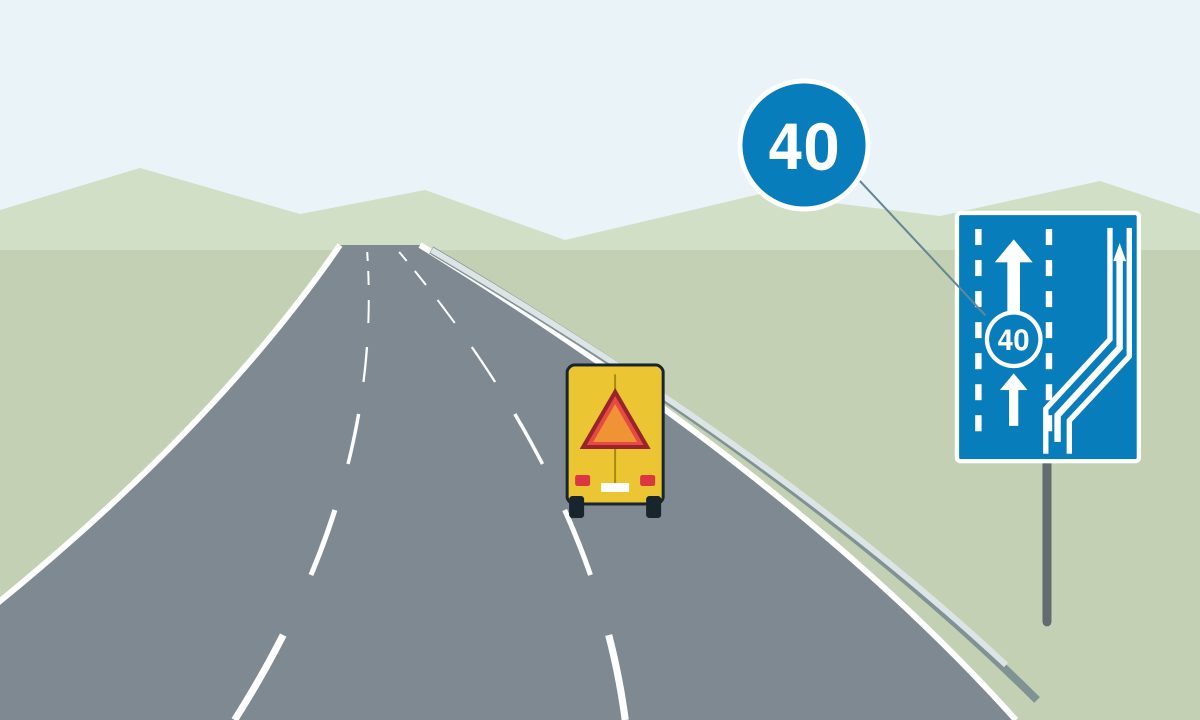 A yellow vehicle with a triangular rear panel on a road curving left; a blue lane sign shows 40 and an upward arrow following the right-hand branch between solid boundaries.